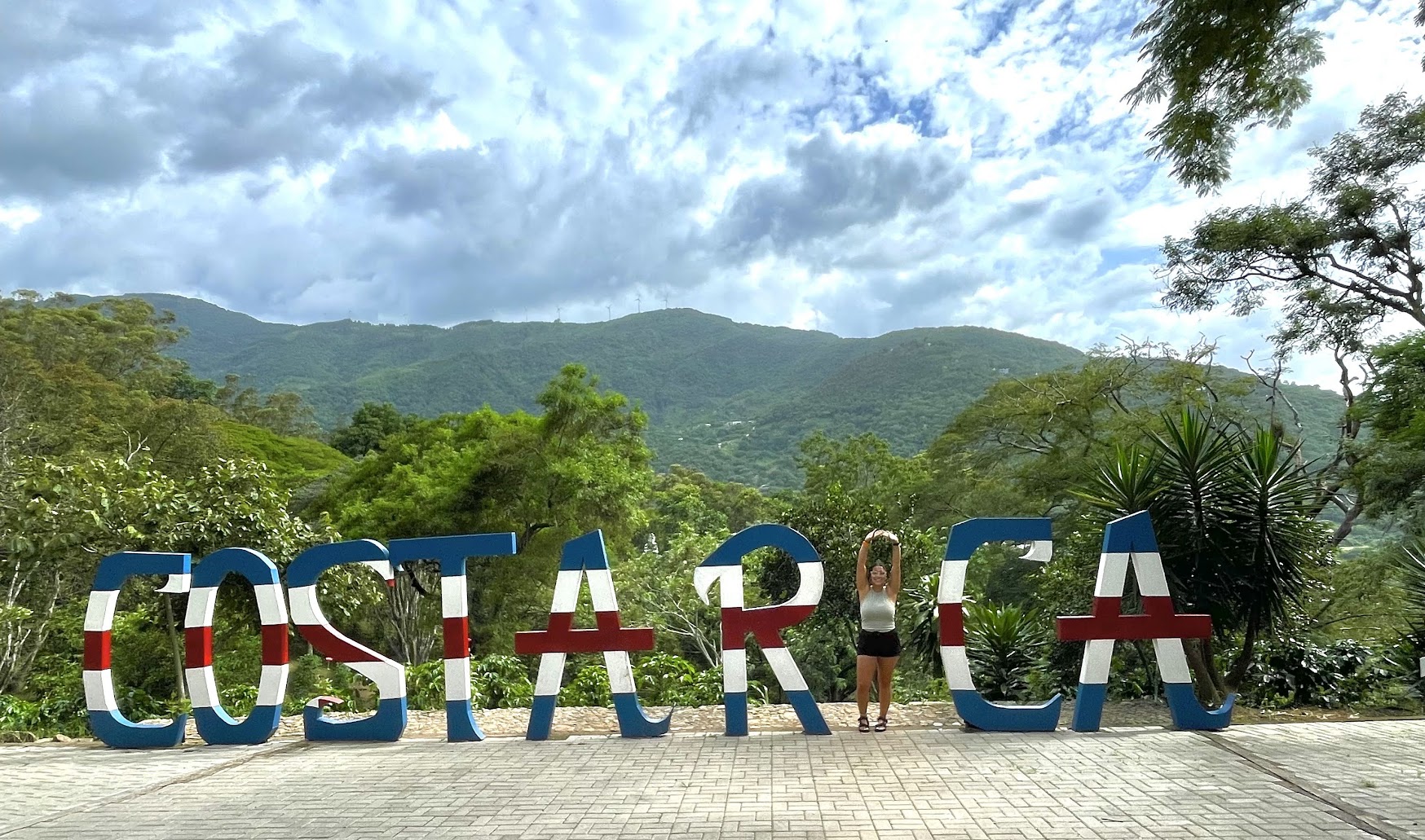UNI Student posing as the "i" in a large "Costa Rica" sign.